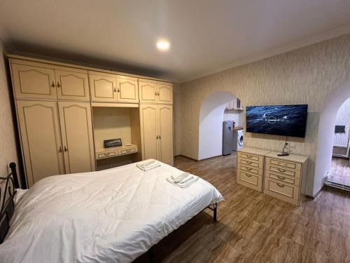 Un dormitorio con una gran cama blanca y un refrigerador. en Tbilisi historical center, en Tiflis