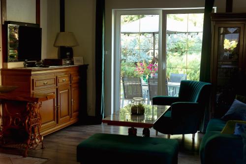 a living room with a couch and a table and windows at Dom wakacyjny Grabówka 18a in Milicz