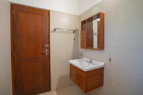 a bathroom with a sink and a wooden door at Villa Amora in Patuwata