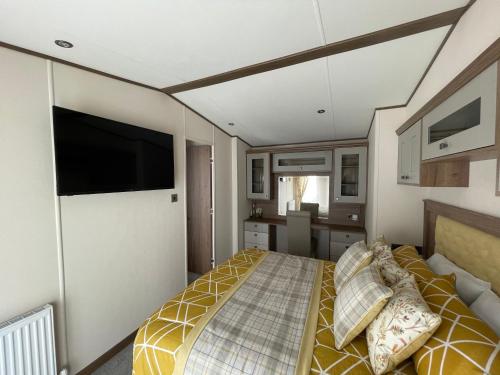 a bedroom with a bed and a flat screen tv at Beaumont Elite in Skelmorlie