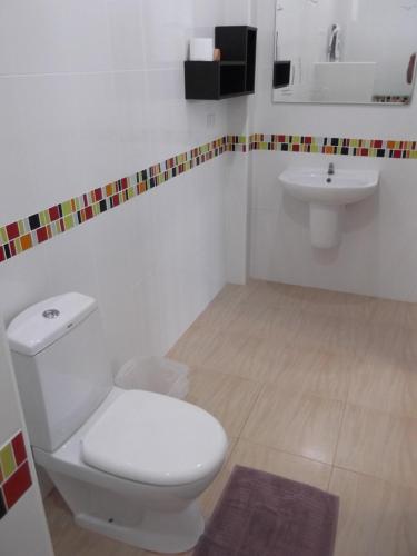 a bathroom with a white toilet and a sink at Nuch's Apple Guest House in Si Bun Ruang