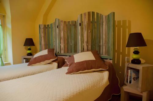 two beds in a bedroom with yellow walls at A L'abri in Saint-Nolff