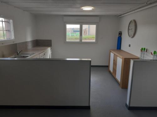 a kitchen with a counter and a clock on the wall at Maison ROSAE Vinca 