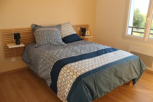 a bedroom with a bed with pillows and a window at Maison ROSAE Vinca 