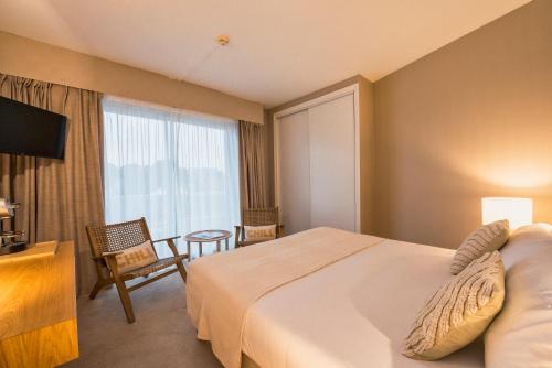 a hotel room with a bed and a window at Hôtel BO & MIA in La Baule