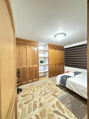a bedroom with a bed and wooden cabinets at Unbeatable location in Medellín in Medellín