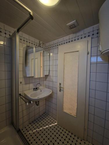 a bathroom with a sink and a mirror and a door at Ferienwohnung-La Casa in Heidenheim