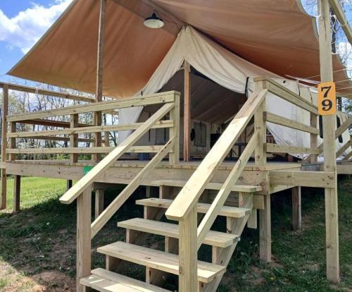 a wooden bed in a tent with a ladder at Cozy Tented Cabin with Fire Pit and Barbecue in Logan, Ohio in Logan