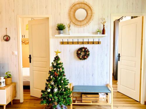 un sapin de Noël dans un salon avec un miroir dans l'établissement Gîte Clair de Lune, à Monts-sur-Guesnes