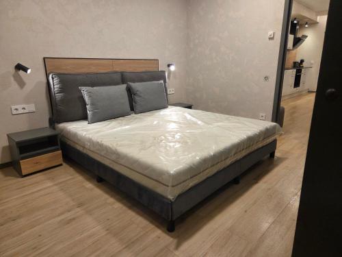 a large bed in a room with a wooden floor at Svečių namas in Radailiai