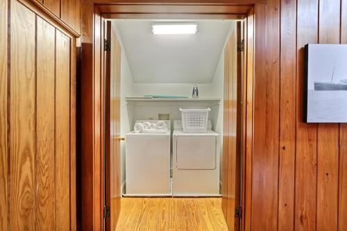 a small white refrigerator in a room with wooden walls at Captain's Quarters on Lafayette in Savannah