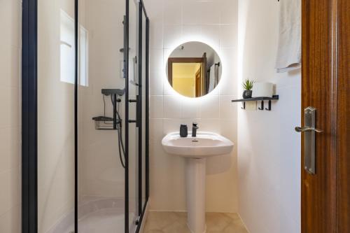 ein weißes Badezimmer mit Waschbecken und Spiegel in der Unterkunft Almarda Beach House in Almardá