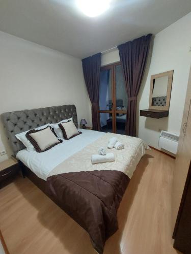a bedroom with a large bed with two towels on it at Ski & Holiday Apartments in Pamporovo in Pamporovo