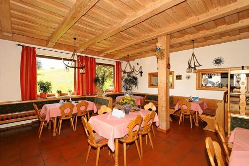 Grandsberg的住宿－Berggasthof-Pension Seminar- und Tagungshaus Menauer，用餐室配有粉红色的桌椅