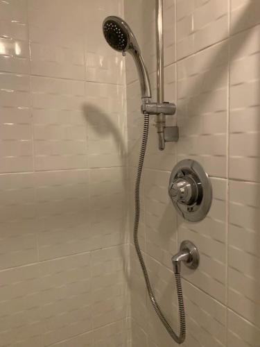 a shower with a shower head in a bathroom at Stylish Apartment Sleeps 6, 2 Bed, 2 Bath, Free Parking & WIFI, Nr NEC & Uni in Coventry