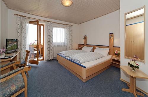 a bedroom with a large bed and a television at Berggasthof-Pension Seminar- und Tagungshaus Menauer in Grandsberg