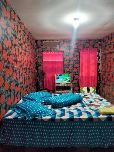 a bedroom with two beds in front of a tv at Penginapan Purple Syariah 