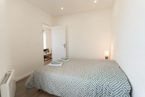 a bedroom with a bed in a white room at Yassam Le 101- Appartement -Gare in Saint-Brieuc