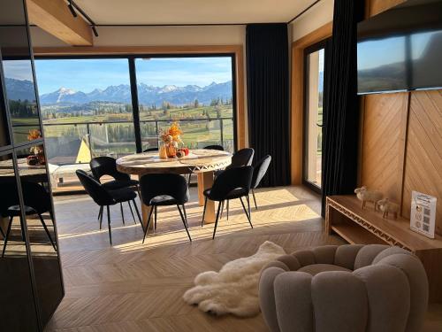 a dining room with a table and chairs and a large window at Tatrzański Horyzont in Biały Dunajec