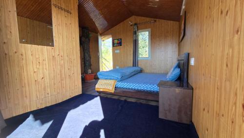 een kleine kamer met een bed in een houten hut bij The City Escape Farmstay in Shimla