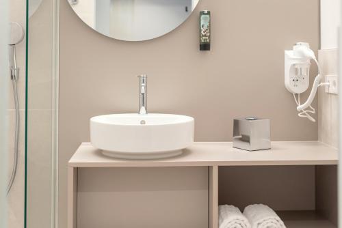 a bathroom with a sink and a mirror at RELAXANS Hotel in Dinkelsbühl