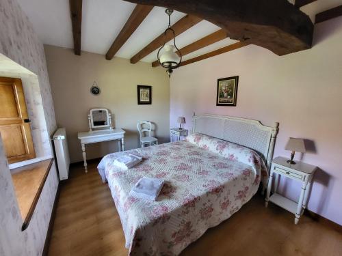 a bedroom with a bed and a table and a sink at Le Logis d'Aliénor - Baie du Mont St-Michel in Baguer-Pican