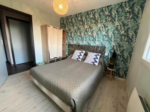 SalguesにあるGîte aux Portes d'Aubracのベッドと緑の壁のある寝室