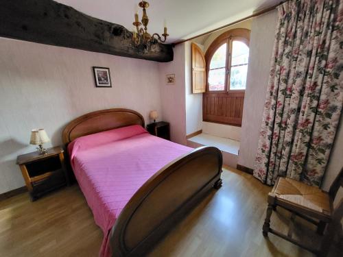 ein Schlafzimmer mit einem rosa Bett und einem Fenster in der Unterkunft La Maison Bienvenüe - Baie du Mont Saint Michel in Baguer-Pican