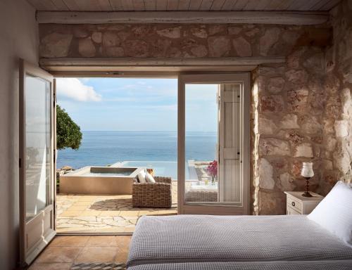 Un dormitorio con vista a una bañera y al océano. en Orfos Villas, en Agios Nikolaos