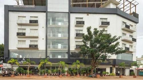 a large white building with a tree in front of it at The Royal Oak in Bhatkal