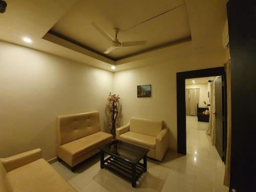 a living room with a couch and chairs and a ceiling at The Royal Oak in Bhatkal