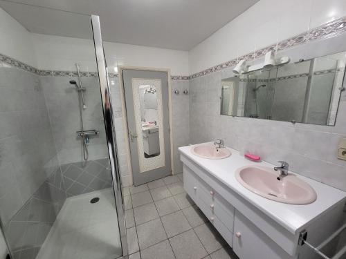 ein weißes Badezimmer mit zwei Waschbecken und einer Dusche in der Unterkunft La Maison Bienvenüe - Baie du Mont Saint Michel in Baguer-Pican