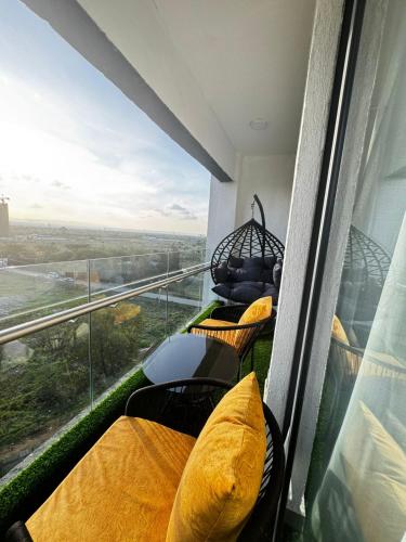 a balcony with yellow pillows and a large window at Artesano one bedroom cozy and comfortable in Syokimau