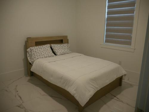 Snowball at the beach في كيب كورال: سرير صغير في غرفة بيضاء مع نافذة