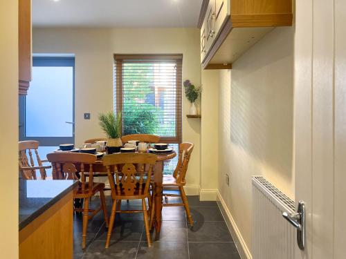 a dining room with a table and chairs in a kitchen at Marina Escape in Swansea