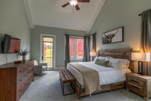 a bedroom with a bed and a dresser and windows at Mountain Top at Linville Falls in Newland