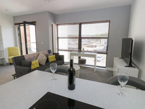 a living room with a bottle of wine on a table at Harbourside Apartment - 1 Bedroom - Sleeps 2 in Whitehaven