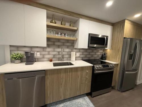 a kitchen with a sink and a refrigerator at Modern and Chic One Bedroom Apartment in Downtown in Halifax