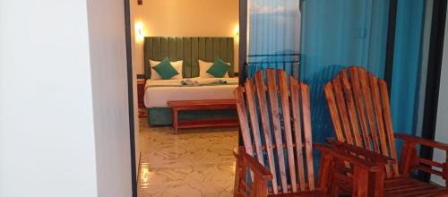 a bedroom with a bed and two rocking chairs at Golden View Guest Ella in Ella