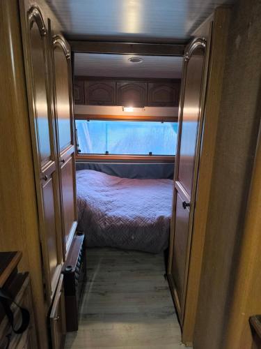 a small room with a bed in an rv at BeauCamp in Rhodes