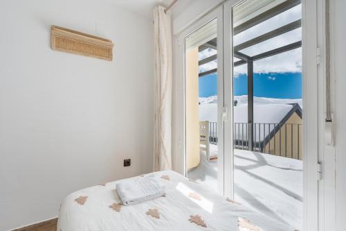 een slaapkamer met een bed en uitzicht op een balkon bij Suite con terraza 31E in Sierra Nevada