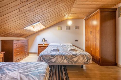 ein Schlafzimmer mit zwei Betten und einer Holzdecke in der Unterkunft The Maisonette Sierra Nevada in Sierra Nevada