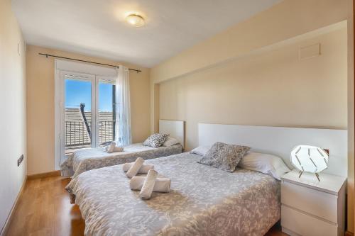 een slaapkamer met twee bedden en een groot raam bij Apartamento Superior 31 C in Sierra Nevada