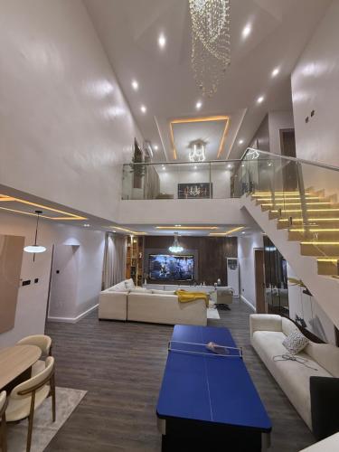 Una sala de estar con una escalera y un sofá. en Luxury Haven Oral, en Ikuata