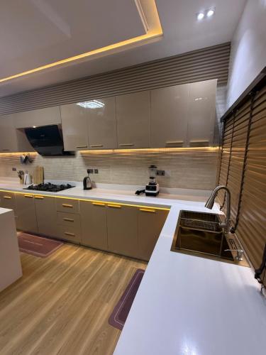 cocina grande con encimeras blancas y suelo de madera en Luxury Haven Oral, en Ikuata