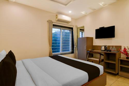 ein Schlafzimmer mit Bett, Schreibtisch und Fenster in der Unterkunft Townhouse The 36 Inn Madhuravada Bus Stop in Rushikonda