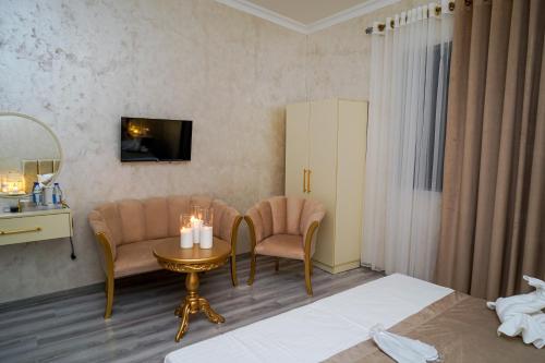 a hotel room with a bed and a table and chairs at Astoria Inn in Toshkent-Passajir Bekati