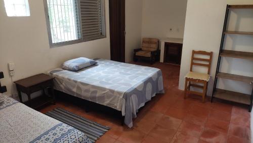 a bedroom with a bed and a chair in it at Casa a 130 metros da praia de Boiçucanga in São Sebastião