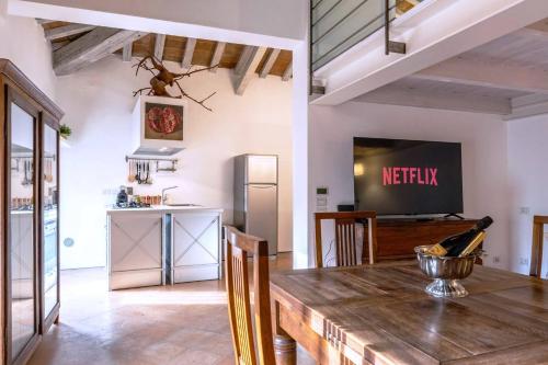 a kitchen and dining room with a table and a television at Luxe Paradise - 4 person, Historic Center in Modena