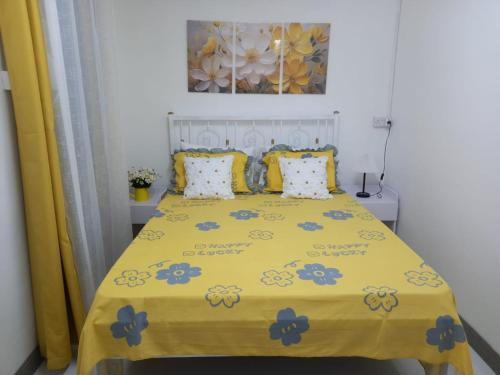 a bedroom with a yellow bed with blue flowers on it at Vue de Vallee in Port Louis